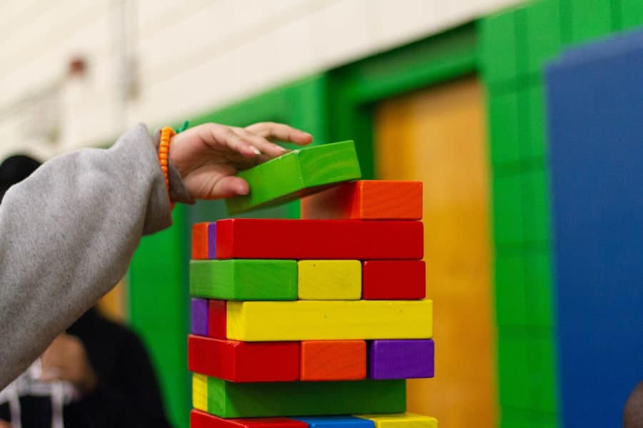 A child stacking colorful blocks during an ABA therapy session